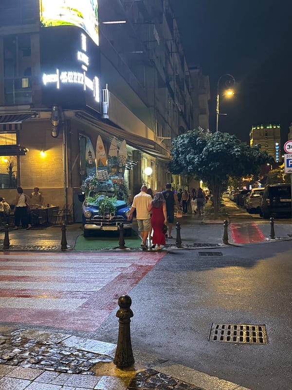 Rainy night on Batumi's Rustaveli Avenue, flower-decked vintage car