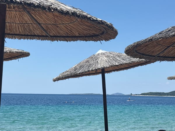 Thatched umbrellas on a sunny Toroni beach, Greece