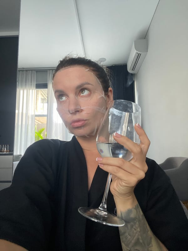 Sheet mask, a glass of water, and a cat on the couch