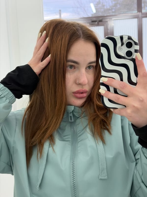 Woman takes selfie on tree-lined walkway in Novopokrovskaya
