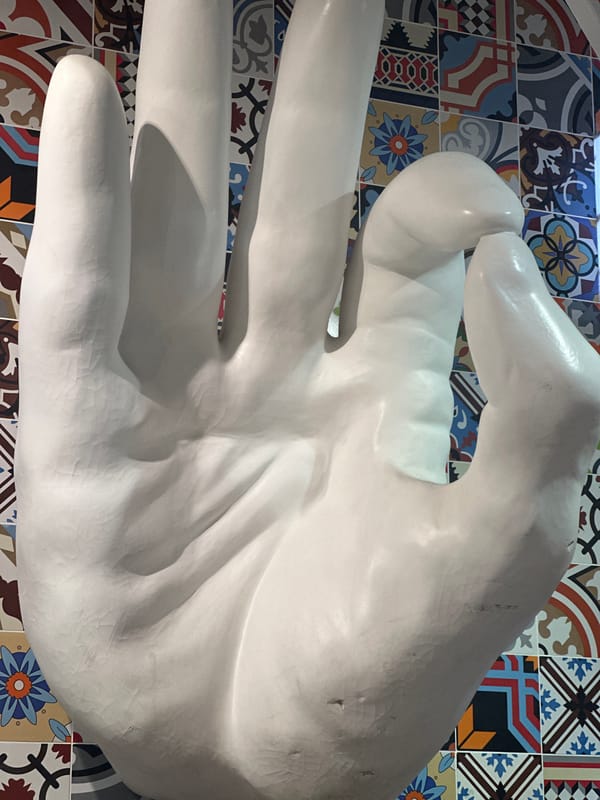 White hand sculpture observed against colorful tiles in Kazan