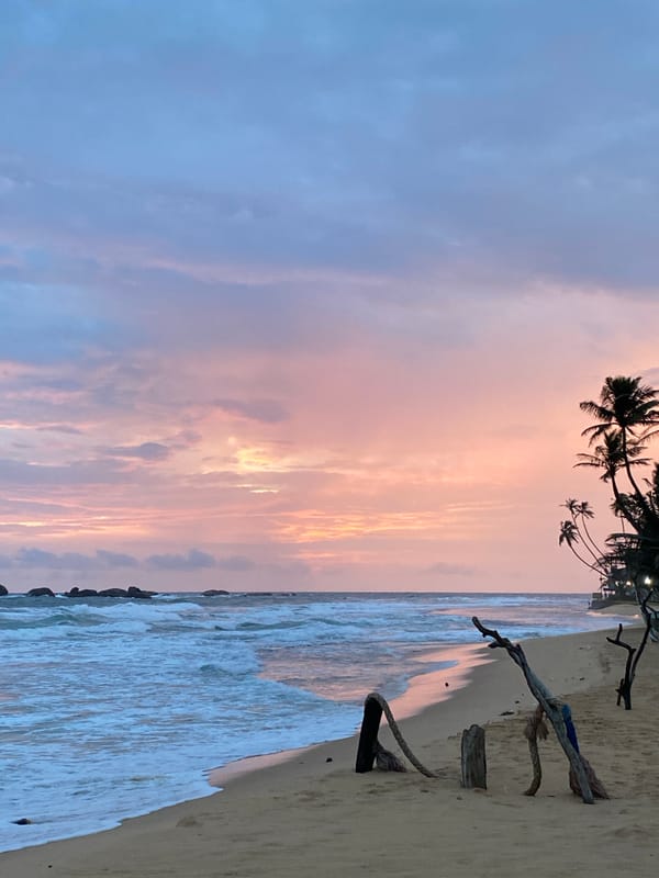 Hikkaduwa beach at sunset, calm waves and palm trees
