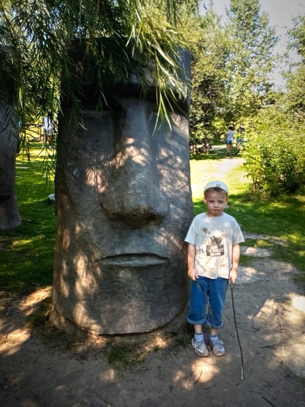 Boy rests on Moai-style sculpture in Solikamsk, Russia