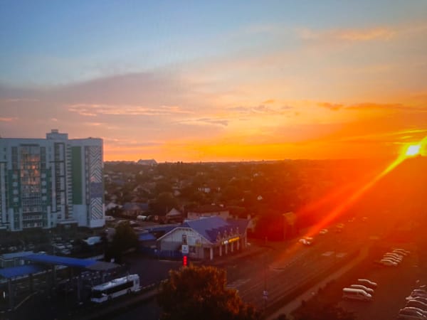 Dusk over Brest: city skyline, highway, and a ceramic skull