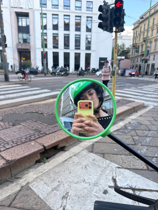Milan street scene captured in green bike mirror reflection