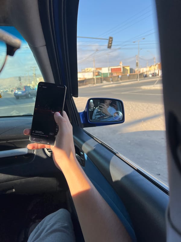 Person uses smartphone in moving car in Arica