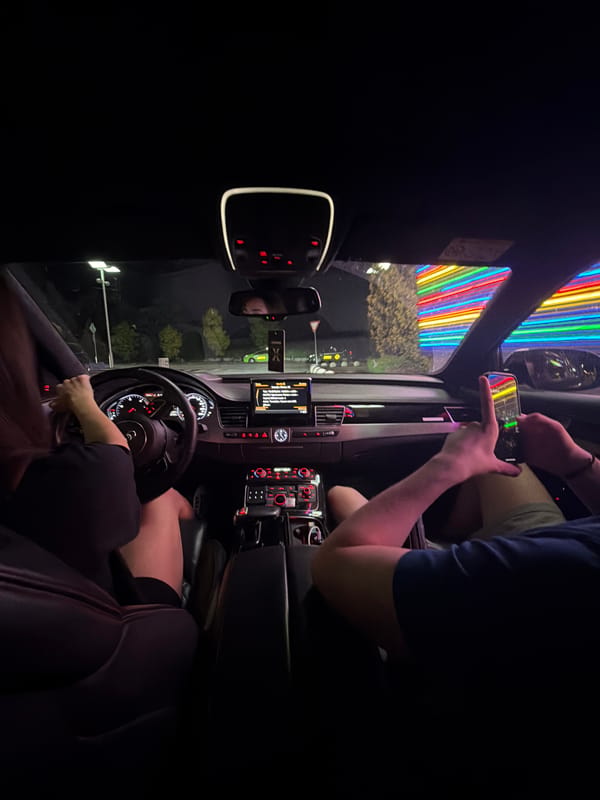 Cruising Ruse at night past neon-lit city landmarks
