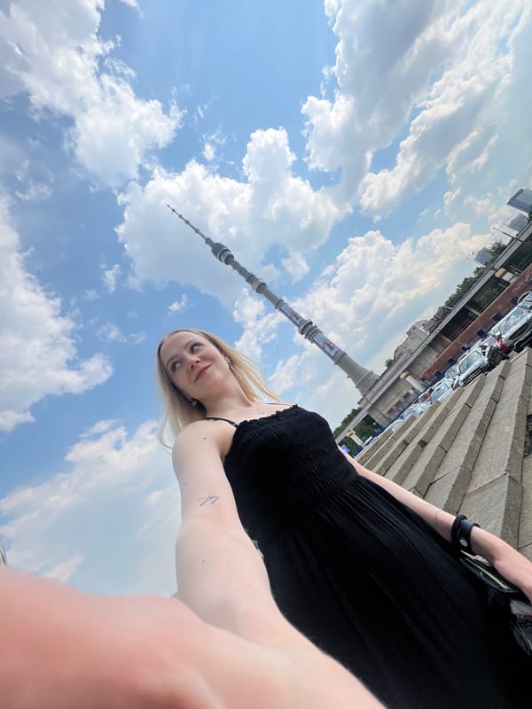Woman takes selfies with Ostankino Tower in Khimki, Russia