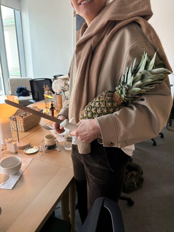 London office worker prepares fresh pineapple for desk snack