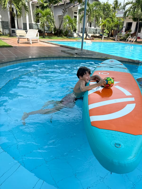 Pool day at a Mũi Né resort with paddleboard and poolside fruit