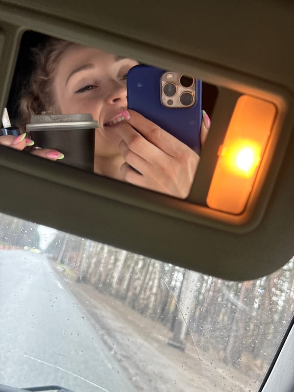 Woman takes selfie in car mirror during rain