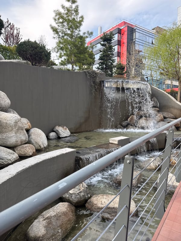 Urban waterfall and modern building documented in city area