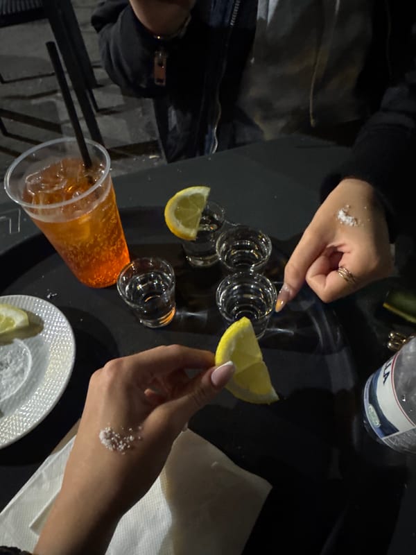 Nighttime tequila gathering observed in Milan with traditional accompaniments
