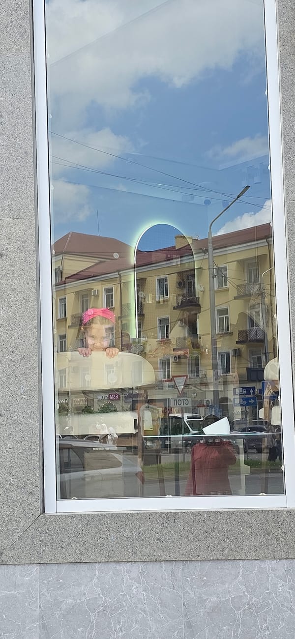 Street reflection captured in Grozny storefront window