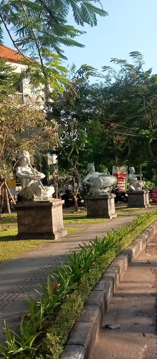 Stone musician sculptures line a walkway in Gianyar, Bali