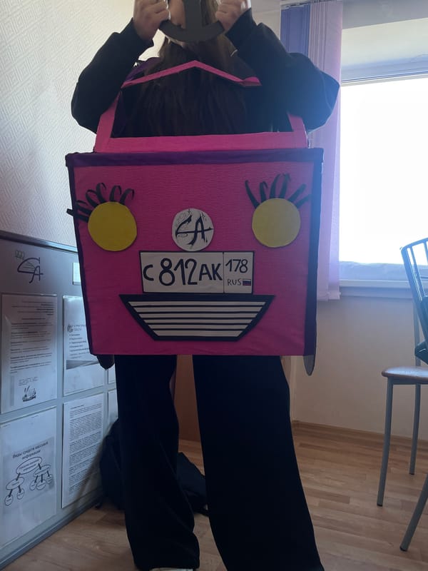 Woman wears elaborate cardboard car costume in Saint Petersburg classroom