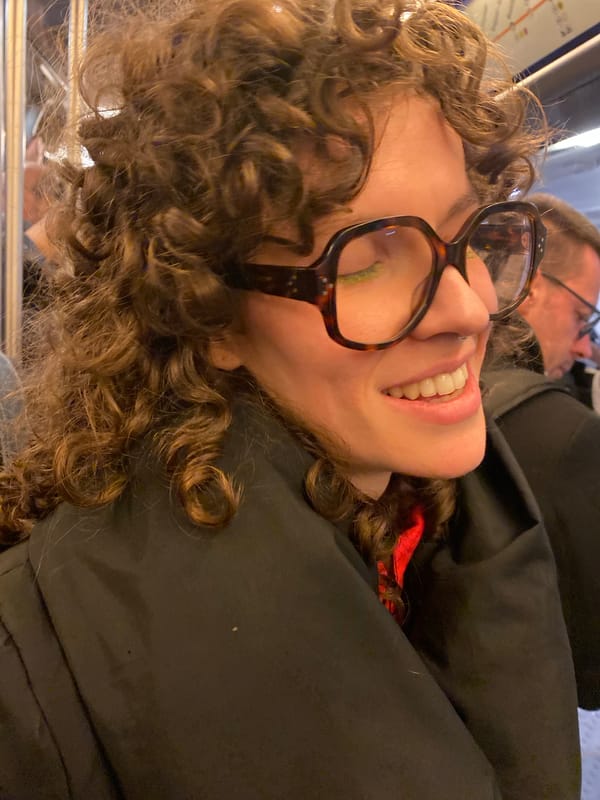 Woman photographed smiling in Paris street scene
