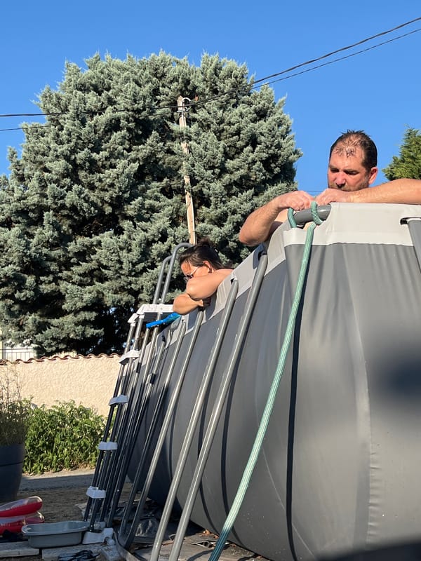Backyard summer hangout: pool, grill, wine, and a balance bike.