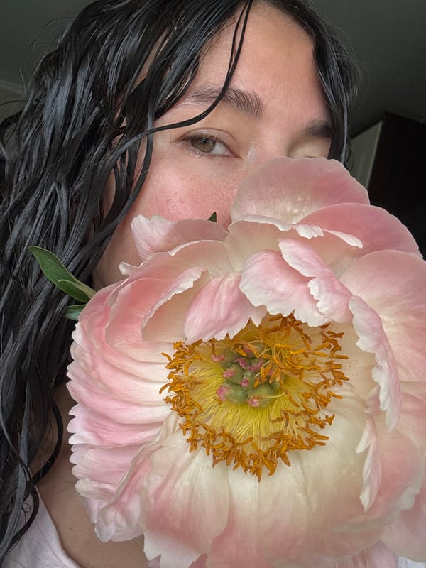 Person poses with peony flowers in Kazan kitchen