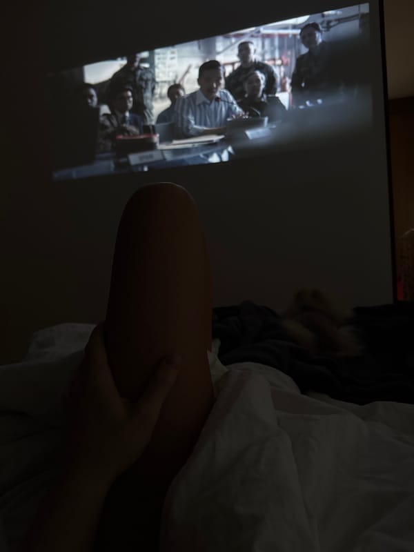 Person rests with injured leg while watching projected film