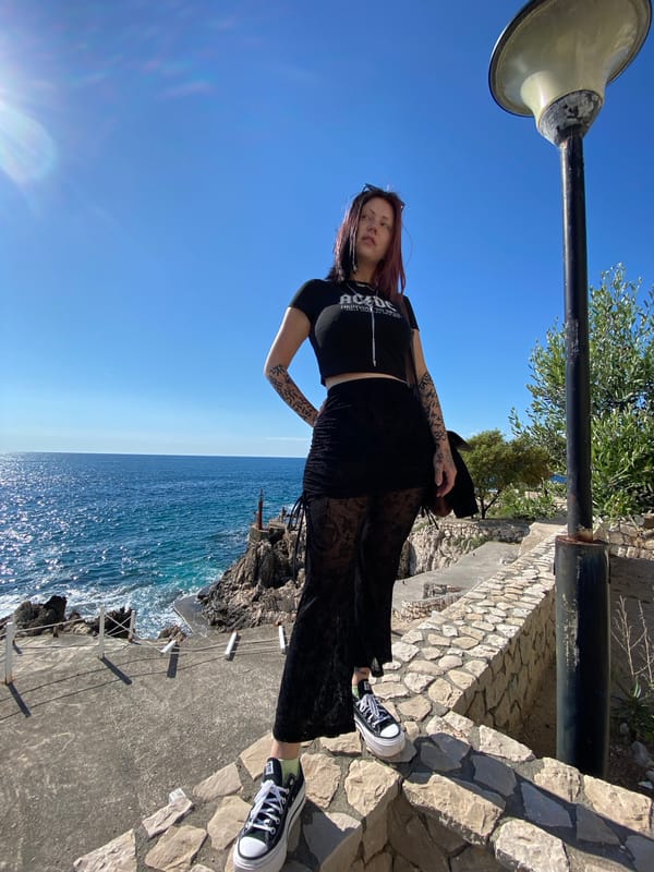 Woman poses on coastal stones in Kunje, Montenegro