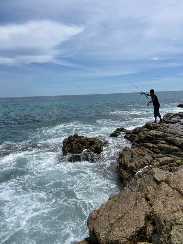 Fishing and exploring a rocky Phuket coastline at sunrise