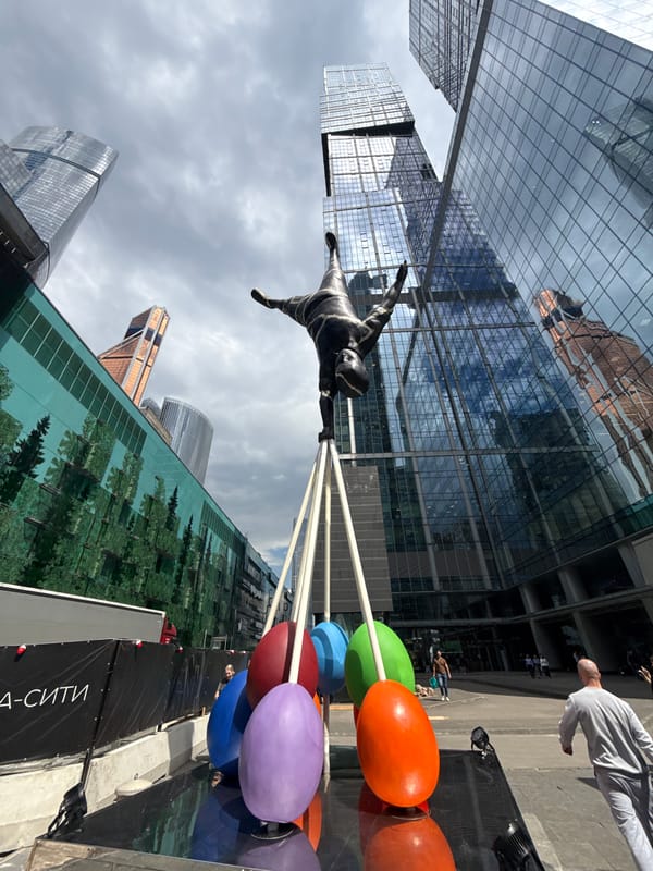 Handstand sculpture stands before Moscow's modern skyscrapers