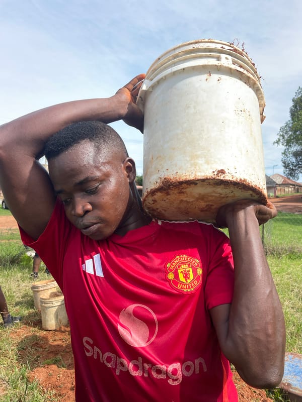 Manual ground work underway on a dusty Jos construction site
