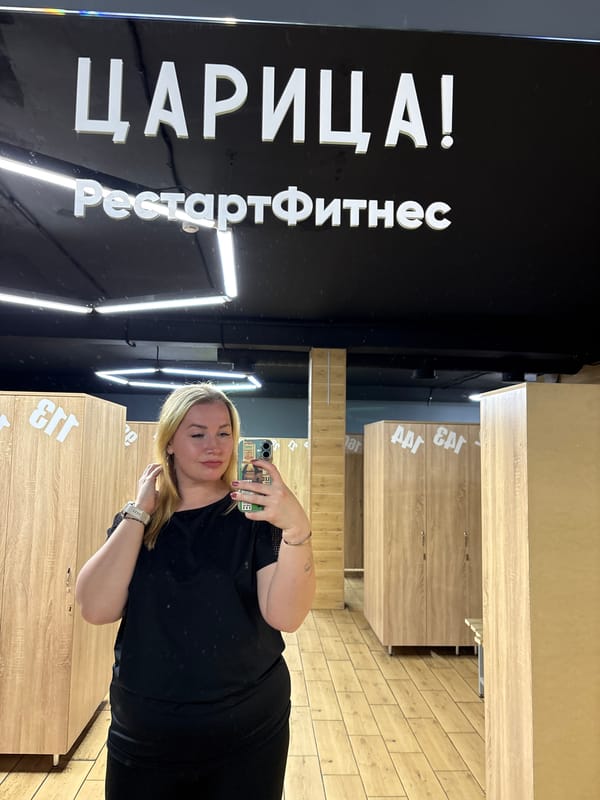 Woman takes selfie near weightlifter mural in Veliky Novgorod