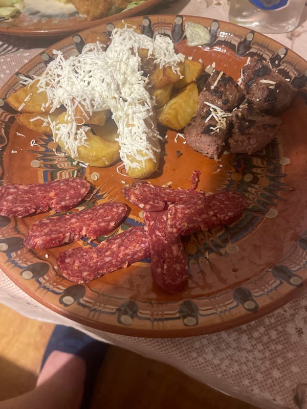 Evening dinner documented with traditional ceramics, cured meats, vodka