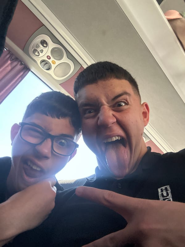 Two men take playful selfie on transport in Greece