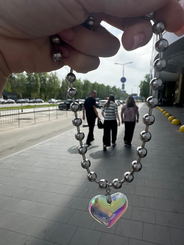 Person documents iridescent heart necklace in Nizhny Novgorod street scenes