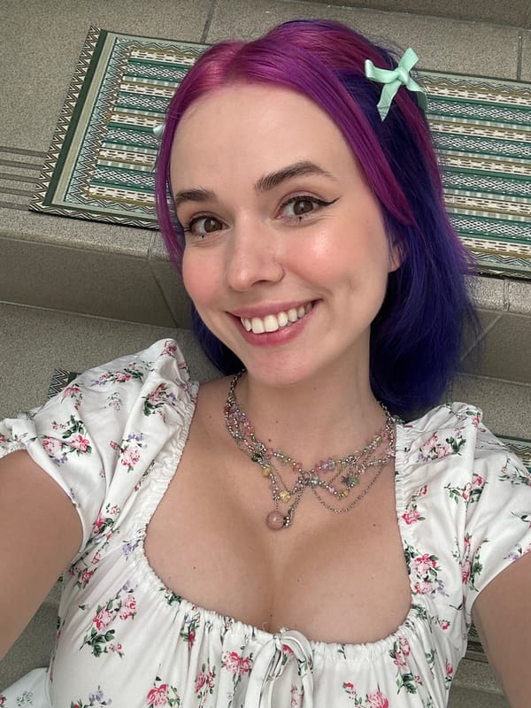 Purple-haired woman poses playfully on Zagreb staircase