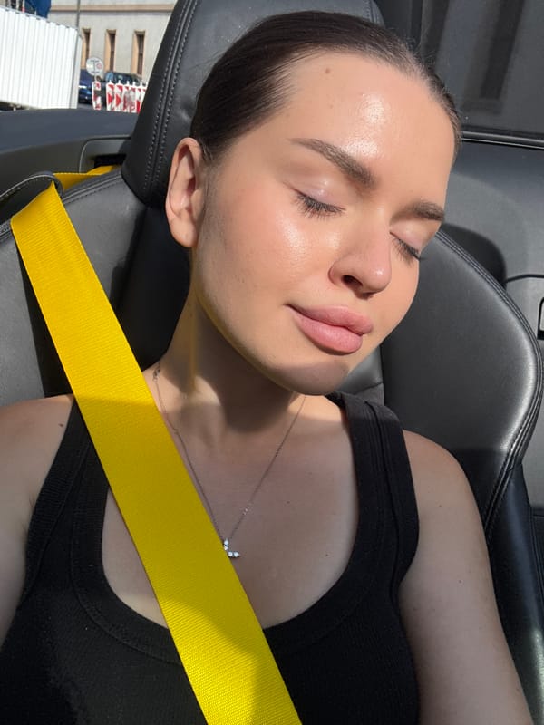 Passenger at rest in a Prague convertible, yellow seatbelt visible