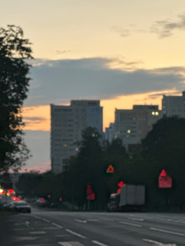 Dusk to night on city streets lined with apartment towers