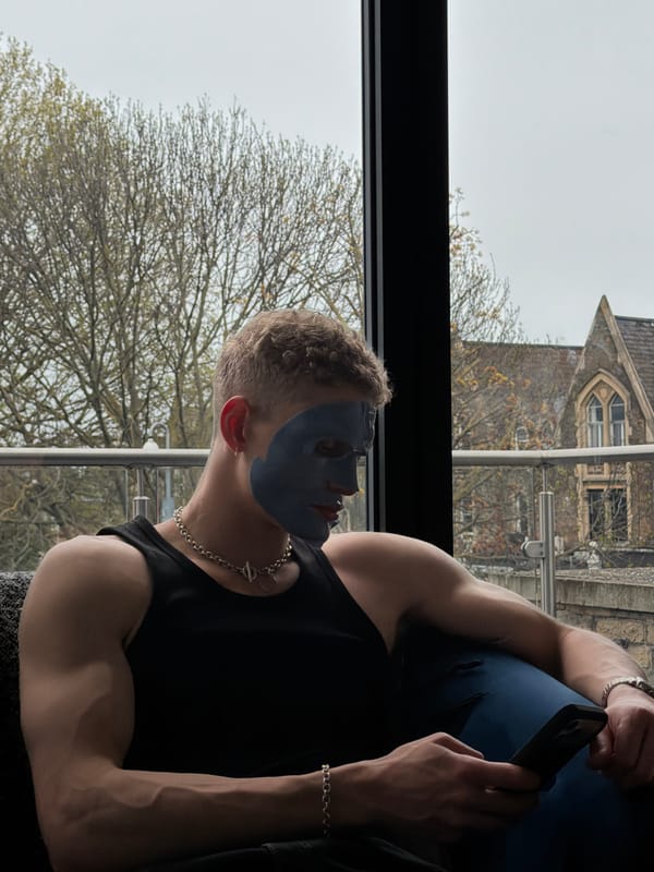 Man in blue face mask uses phone by London window