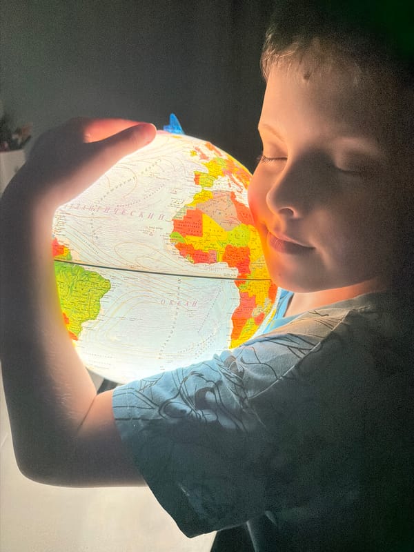 Child explores world globe, reads scary stories in Votkinsk bedroom