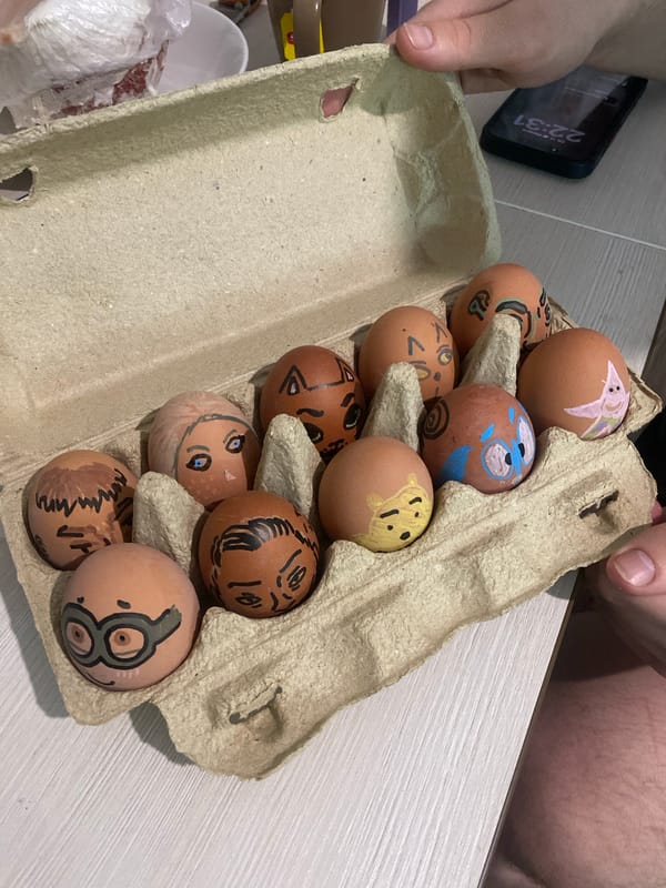 Person decorates brown eggs with cartoon faces in Izhevsk