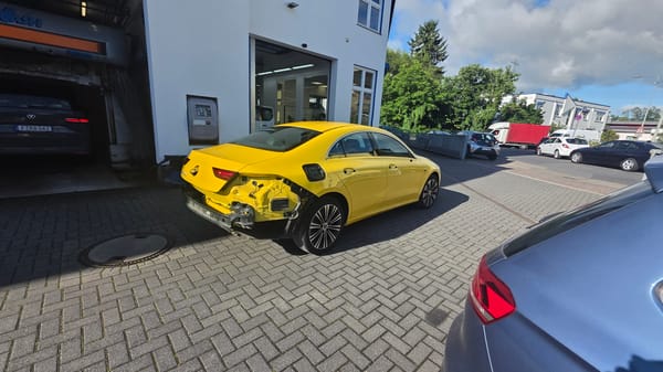 Damaged Yellow Mercedes Observed at Commercial Building