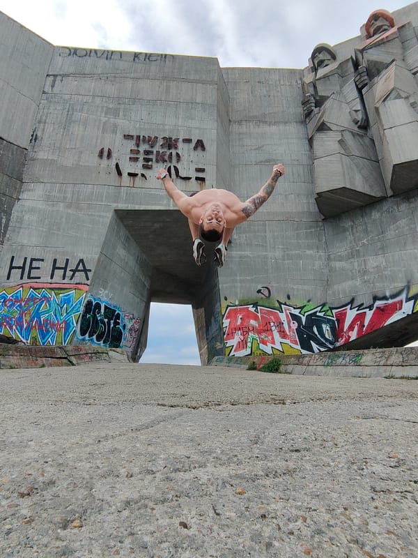 Man performs acrobatics at graffitied Bulgarian Soviet monuments