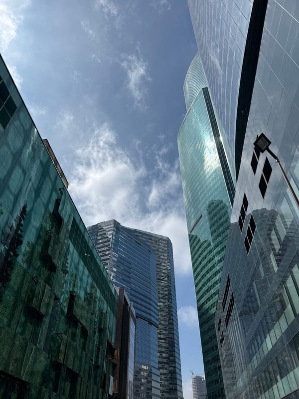 Witness captures upward view of clustered glass buildings
