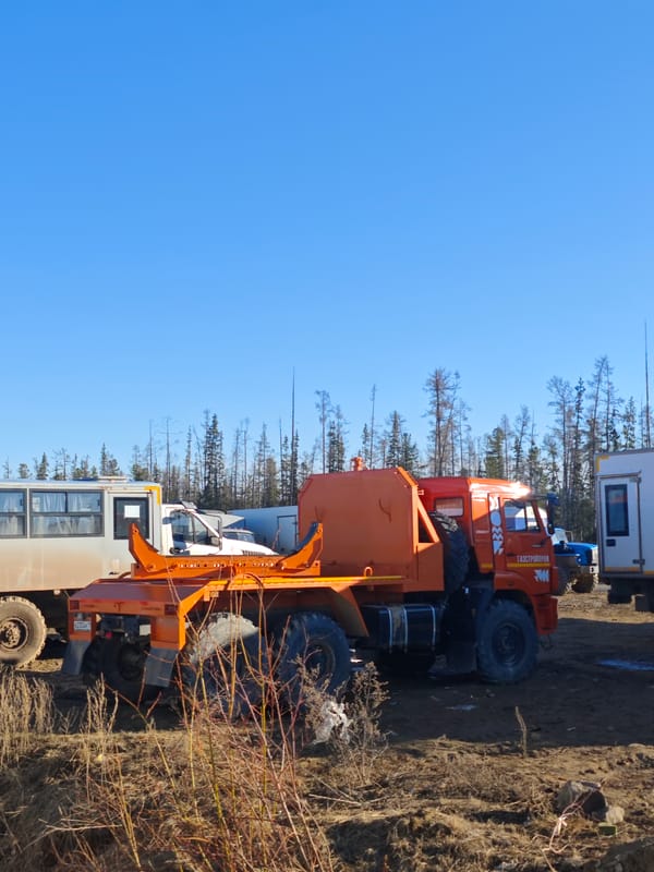 Construction site with orange truck, gravel piles observed in Russia