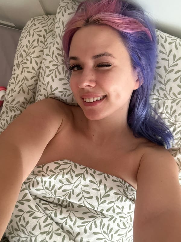 Woman with colorful hair photographed resting in Gijón bedroom