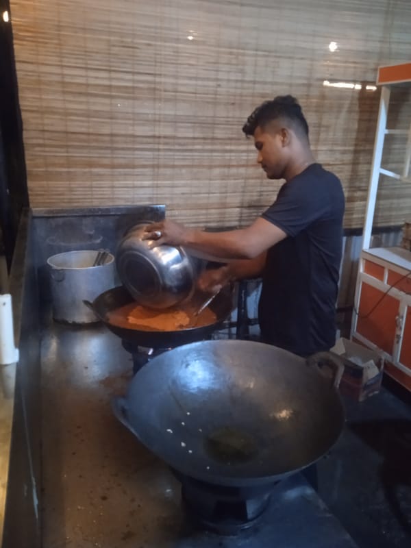 Man cooking with dark sauce and rice takeout observed