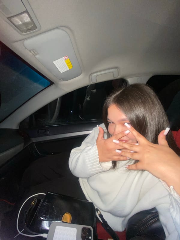 Person covers face in car passenger seat in Rusalevka