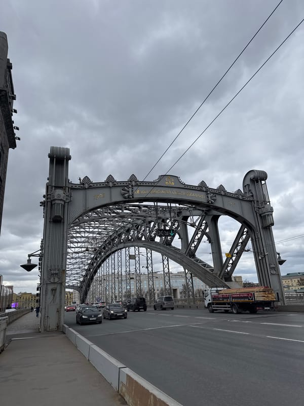 Ornate truss bridge observed under grey skies in Saint Petersburg