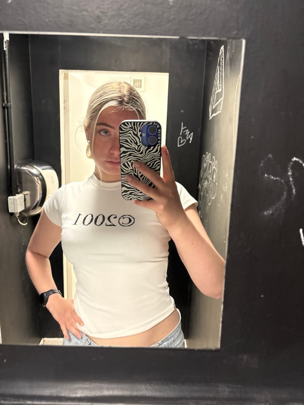 Woman takes mirror selfie in graffitied Manchester interior