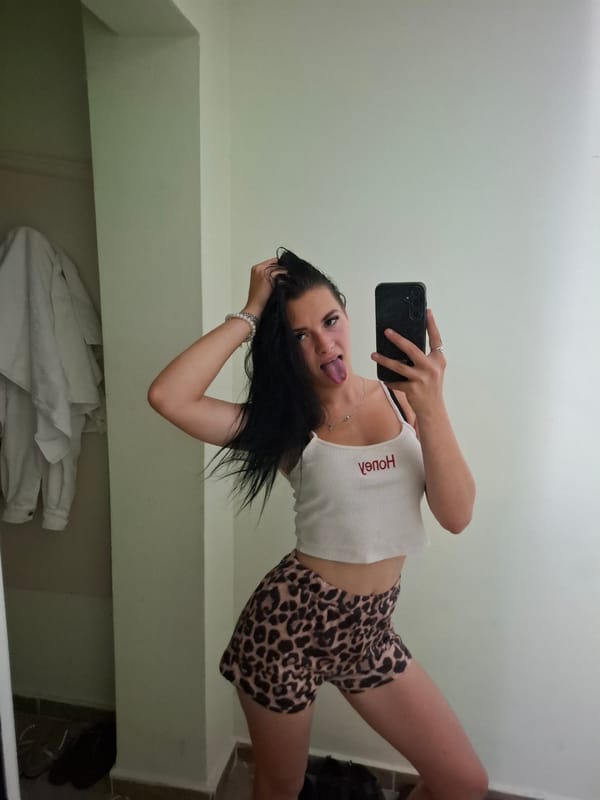 Mirror selfie in Varna bedroom, leopard print and red lettering