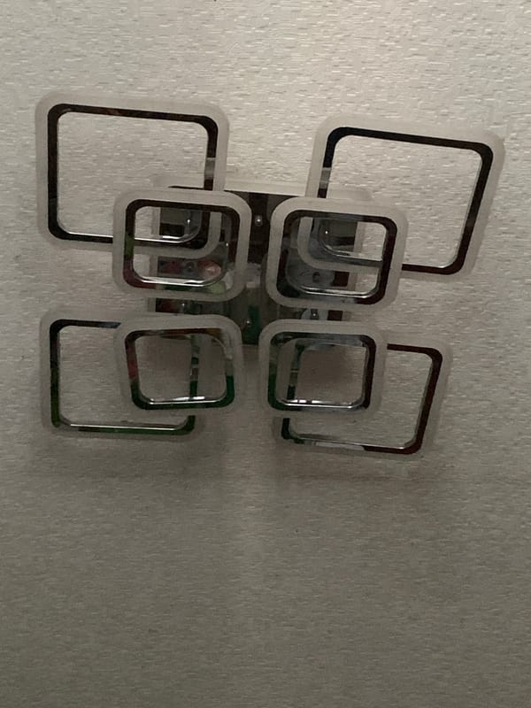 Interior wall details: chrome light fixture and mounted TV