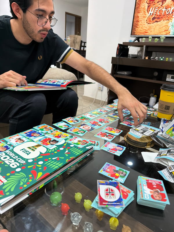 Man reviews FIFA 2026 sticker album at home
